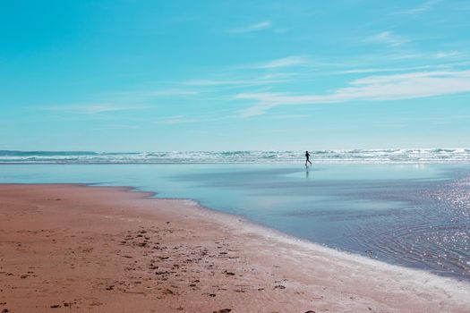 Silhouette of lone jogger on Mawgan Porth beach, Cornwall, UK