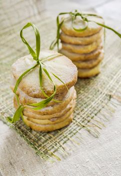 Homemade lemon sugar cookies tied up with rope on linen tablecloth, blurred background From series Winter pastry