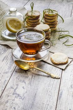 Homemade lemon sugar cookies and cup of hot tea on linen tablecloth From series Winter pastry