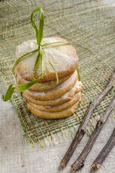 Homemade lemon sugar cookies tied up with rope and dried branches on linen tablecloth, blurred background From series Winter pastry