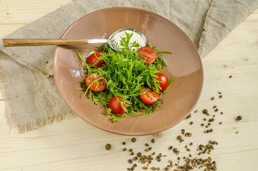 Watercress salad with cherry tomatoes and sour cream. Overhead view. From series Natural organic food