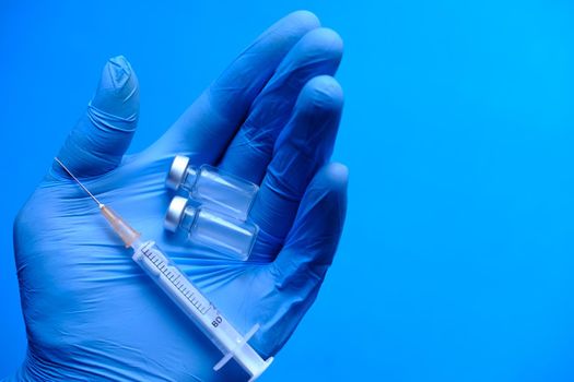 vaccine and syringe on doctor's hand top view .