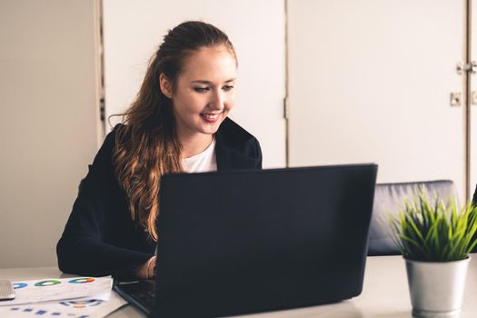 Young businesswoman work using laptop computer at the office desk. Business internet concept.