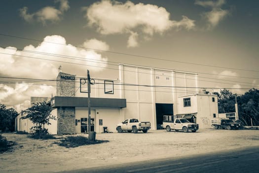 Tulum Mexico 02. February 2022 Old black and white picture of driving thru typical colorful street road and cityscape with cars traffic palm trees bars and restaurants of Tulum in Mexico.