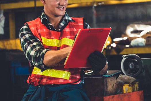 Manufacturing worker working with clipboard to do job procedure checklist . Factory production line occupation quality control concept .