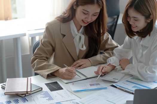 Young Asian businesswoman work together to analysis from work at the office..