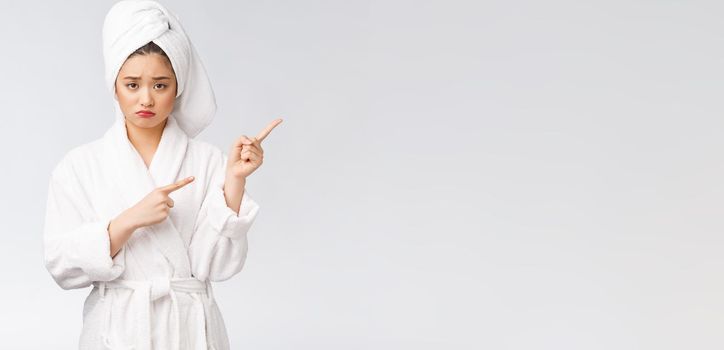 Young beautiful woman wearing shower towel after bath over isolated white background pointing with finger