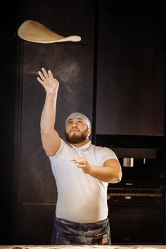 Making dough by hands at bakery or at home. Flour cloud in the air.