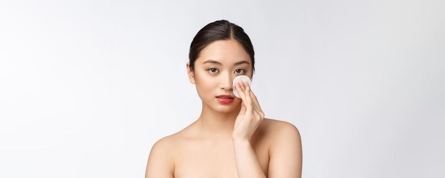 skin care woman removing face makeup with cotton swab pad - skin care concept. Facial closeup of beautiful mixed race model with perfect skin