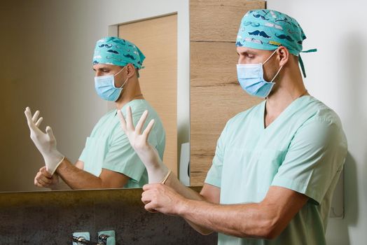 Doctor watches on hands with sterile medical gloves on his hands to protect against a pandemic of coronavirus covid 19 in China. Hygiene for hands