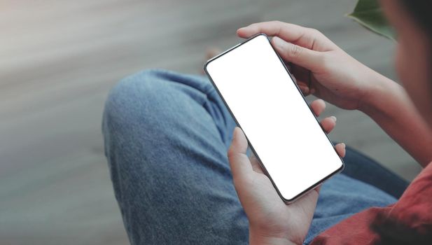 Top view Woman sitting and holding blank screen mock up mobile phone.