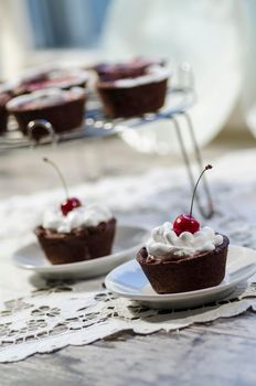 Chocolate dessert decorated with whipped cream and a cherry