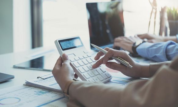 Businesswoman holding calculator for calculate financial data at meeting room, Business Financing Accounting Banking Concept.