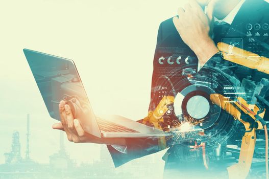 Mechanized industry robot arm and factory worker double exposure . Concept of robotics technology for industrial revolution and automated manufacturing process .