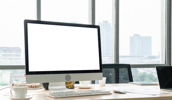 Empty computer monitor screen for design mock up template in modern small office interior or home office. Stylish workplace for creative occupation.