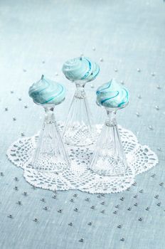 Three homemade meringue shaped domes on crystal wine-glasses, blurred background From series Christmas and New Year