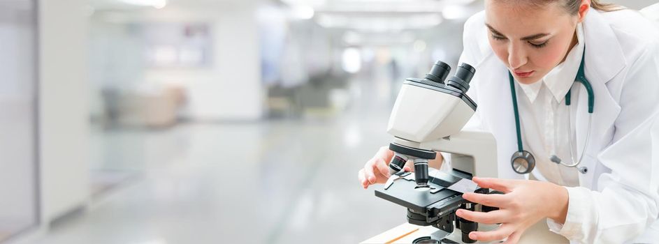 Scientist researcher using microscope in laboratory. Medical healthcare technology and pharmaceutical research and development concept.