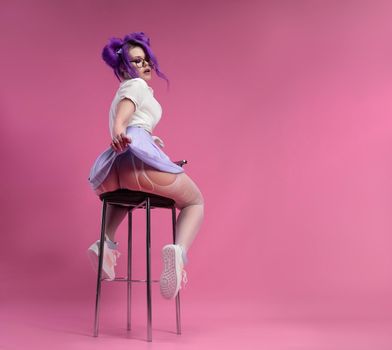 the sexy girl with purple hair in summer clothes and beautiful underwear on a pink background