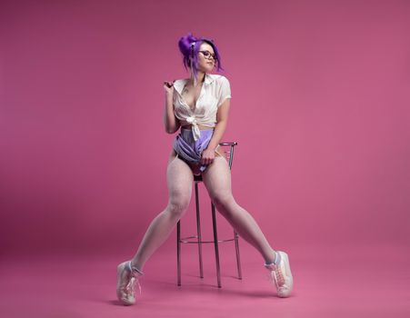 the sexy schoolgirl girl with purple hair in summer short clothes and beautiful underwear on a pink background