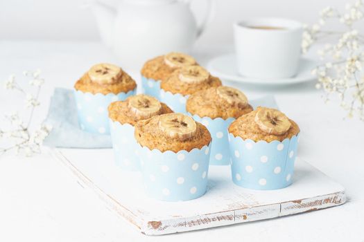 Banana muffin, cupcakes in a blue cake cases paper, white concrete table