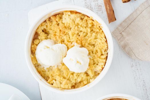 Apple crumble with ice cream, streusel. Morning breakfast on light gray table. Top view, close up