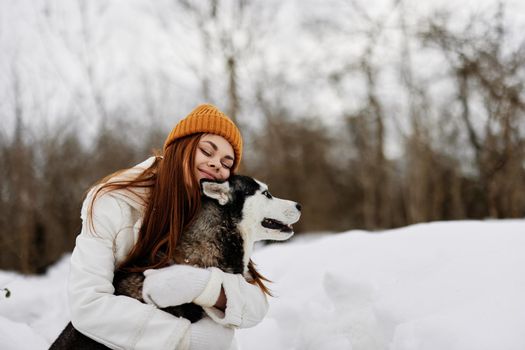 woman outdoors in a field in winter walking with a dog Lifestyle. High quality photo