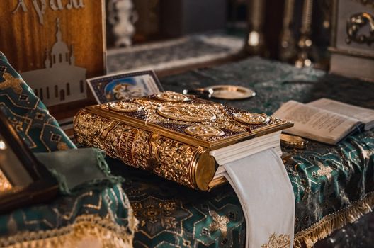 The holy book, the Bible in gold, lies at the altar in the church.