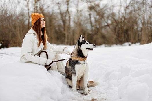 woman in the snow playing with a dog fun friendship winter holidays. High quality photo