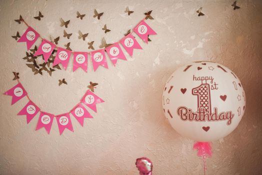 White-pink air helium balloons in honor of the child birthday. decoration of a children party for a girl