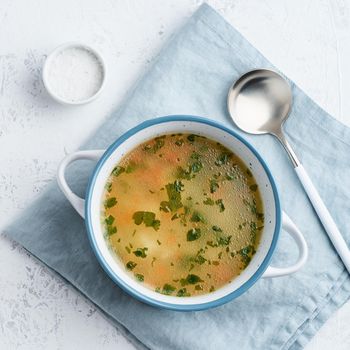 chicken soup, scandinavian homemade food with on a blue stone table, top view