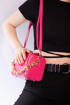 womans hand holding a pretty little pink handbag. Product photography. stylish handbag and purse for women