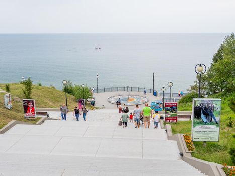 SVETLOGORSK, RUSSIA - July 21, 2019. Tourists near mosaic sun clocks Zodiak by Nikolay Frolov, art landmark of sea embankment of Svetlogorsk.