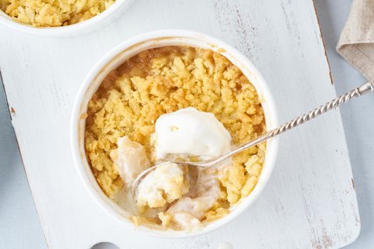 Apple crumble with ice cream, streusel. Morning breakfast on light gray table. Top view, close up