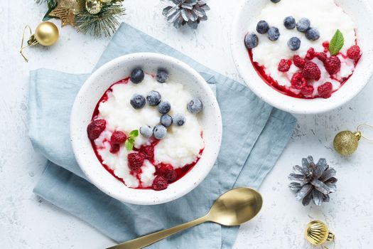 Christmas food, rice pudding, top view. Healthy Vegan diet breakfast with coconut milk, a berries, scandinavian minimalism