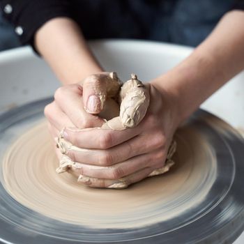 Woman making ceramic pottery on wheel, hands close-up, creation of ceramic ware. Handwork, craft, manual labor, buisness. Earn extra money, turning hobbies into cash and passion into a job, close up