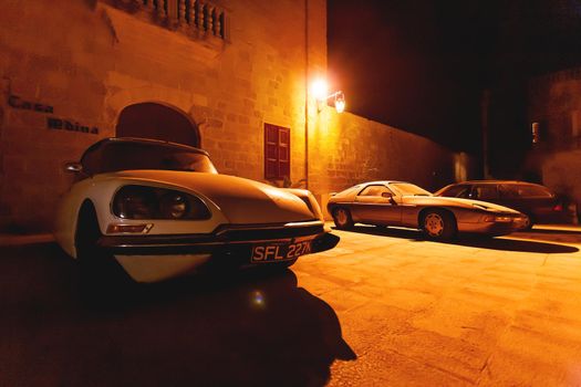MDINA, MALTA - February 19, 2010. Old timer cars parked near stony buildings of Mdina, ancient capital of Malta.