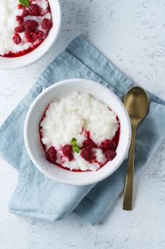 Rice Pudding. Vegan Coconut diet breakfast with a coconut milk, raspberry, scandinavian minimalism, vertical, top view, copy space