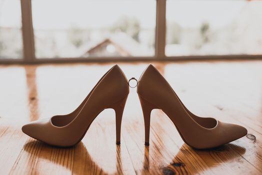 a ring between two women's high heel shoes. Morning of the bride