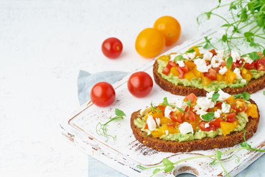 avocado toast with feta and tomatoes, smorrebrod with ricotta, closeup with copy space