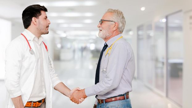 Doctor in hospital handshake with another doctor. Healthcare people teamwork and medical service concept.