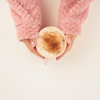 morning hot coffee on cold autumn morning, hands holding a mug with a drink, cozy atmosphere, top view, copy space