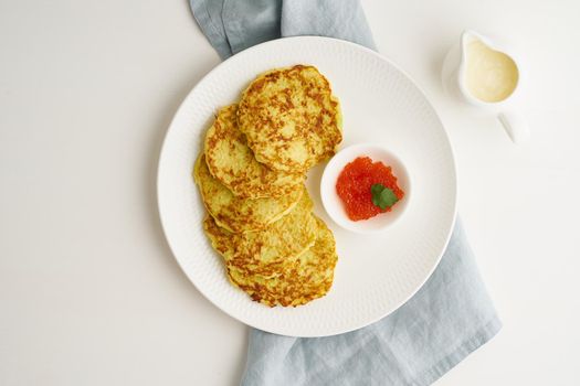 Balanced and gluten free zucchini pancakes with red caviar and sause