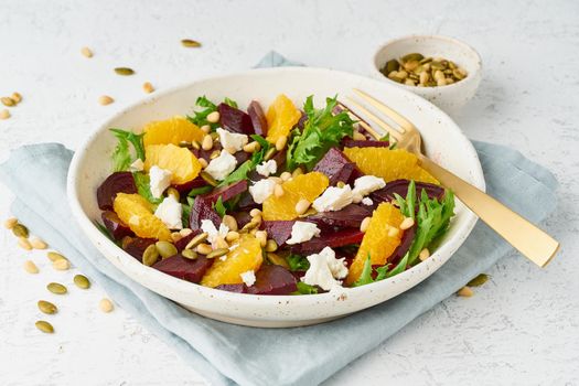 salad with beet, curd, avocado, orange, feta, ricotta and pumpkin seeds, keto ketogenic dash diet, modern and pastel background, closeup