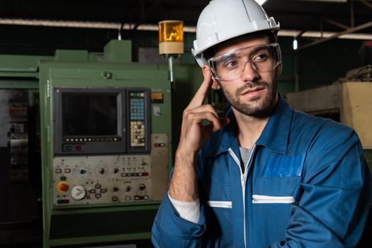 Skillful factory engineer or worker portrait while thinking and looking forward . Industrial people and manufacturing labor concept .
