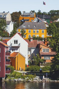 TRONDHEIM, NORWAY - July 15, 2017. Colorful buildings of Trondheim. People walk on streets at sunny day. Scandinavian style of architecture.