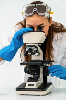 Young woman scientist working in chemical laboratory and examining biochemistry lab sample. Science technology medicine research and development study concept.