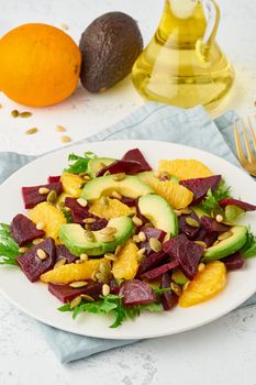 salad with beet, curd, avocado, orange, feta, ricotta and pumpkin seeds, keto ketogenic dash diet, modern and pastel background, closeup vertical