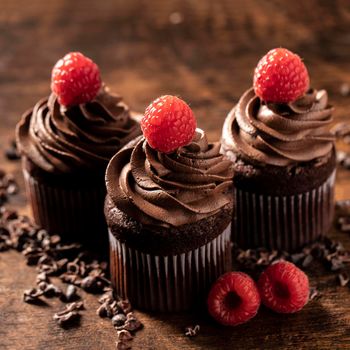 close up delicious chocolate cupcakes with raspberry