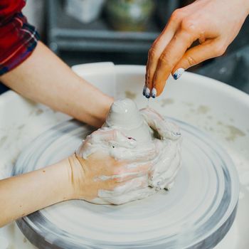 Women making ceramic pottery, concept for a workshop and master class, four hands close-up, focus on potters, palms with pottery. Two woman. Creative hobby concept. Earn extra money, side hustle