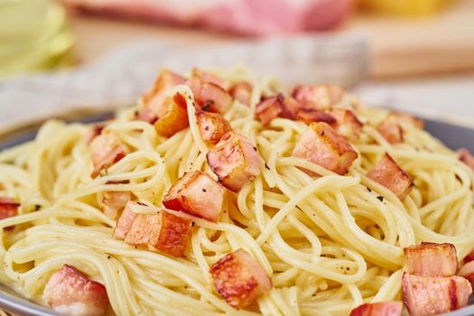 Close up carbonara pasta. Spaghetti with pancetta, egg, parmesan cheese and cream sauce. Side view. Traditional italian cuisine.